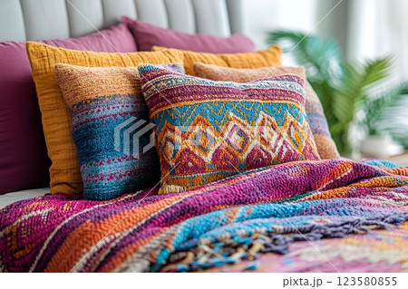 Decorative pillows with bohemian patterns on a cozy bed, creating a warm and stylish bedroom ambiance 123580855