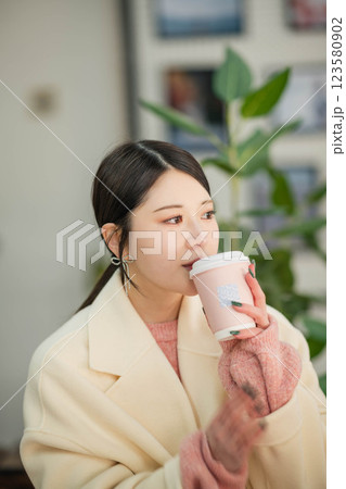 室内で飲み物を飲む若い女性 123580902