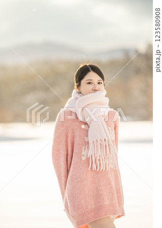 冬の温かい光の中にいるニット姿の若い女性 冬の温かい光の中にいるニット姿の若い女性 123580908