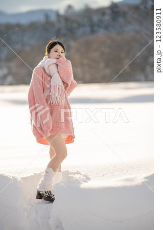 冬の温かい光の中にいるニット姿の若い女性 冬の温かい光の中にいるニット姿の若い女性 123580911