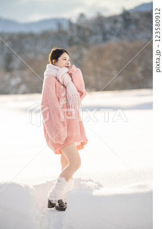 冬の温かい光の中にいるニット姿の若い女性 123580912