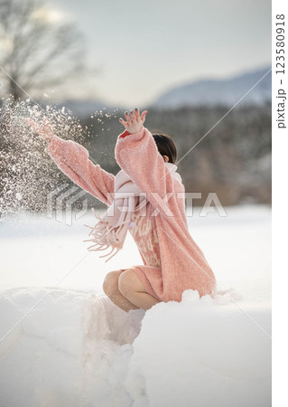 冬の温かい光の中にいるニット姿の若い女性 123580918