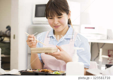 昼食のお弁当を食べる女性介護福祉士 昼食のお弁当を食べる女性介護福祉士 123581710