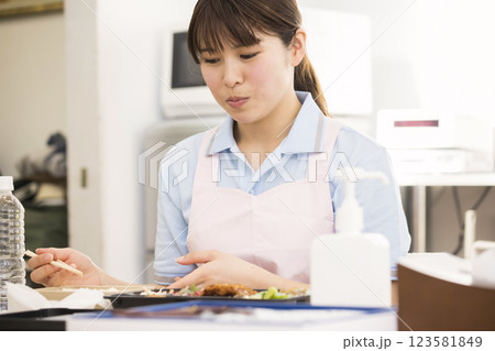 昼食のお弁当を食べる女性介護福祉士 123581849