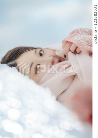 雪の上に寝転ぶ若い女性 123582031