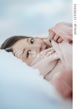 雪の上に寝転ぶ若い女性 123582032