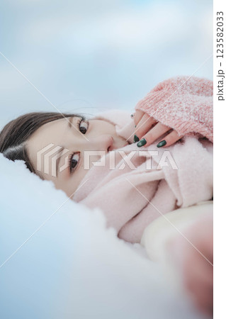 雪の上に寝転ぶ若い女性 123582033