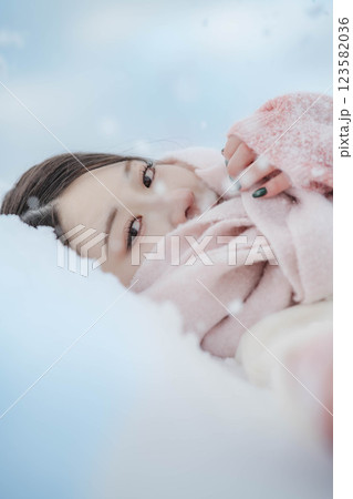 雪の上に寝転ぶ若い女性 123582036