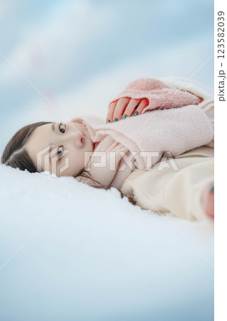 雪の上に寝転ぶ若い女性 123582039