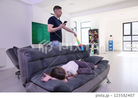 A Father is spending quality time with his Child in a Modern Living Room setting A Father is spending quality time with his Child in a Modern Living Room setting 123582407