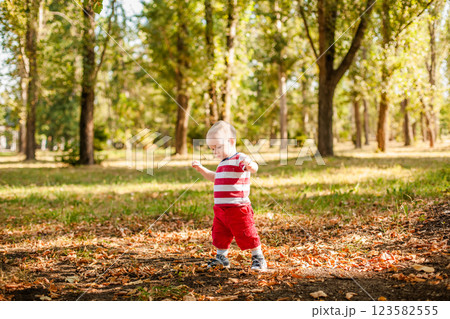 One-year-old little boy exploring the world in an autumn forest One-year-old little boy exploring the world in an autumn forest 123582555