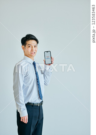 スマホを持つ20代の若い男性 NISAvsiDeCo スマホを持つ20代の若い男性 NISAvsiDeCo 123583463
