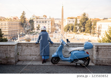Elegant Woman Admiring Rome with Her Scooter 123583652