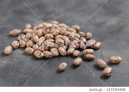 Pile of dried raw uncooked pinto beans on dark gray table closeup. Traditional Latin American legumes 123584406