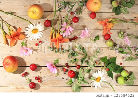 Abstract floral composition, background, holiday concept with flowers, spring and summer banner. Lily flowers, mint, mallow, daisies, apples, cherries and plums on a sunny table, postcard with space 123584522