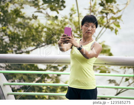 young asian woman taking a selfie outdoors 123585275
