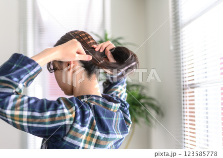 髪をまとめる女性の後ろ姿 髪をまとめる女性の後ろ姿 123585778