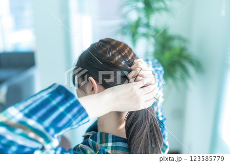 髪を束ねる女性の後ろ姿 髪を束ねる女性の後ろ姿 123585779