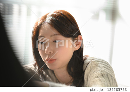 朝の日差しの中で考え事をする女性 朝の日差しの中で考え事をする女性 123585788