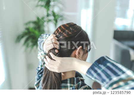 髪を結ぶ女性の後ろ姿 髪を結ぶ女性の後ろ姿 123585790
