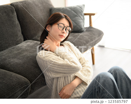 首に手を添える女性のリラックスした表情 首に手を添える女性のリラックスした表情 123585797