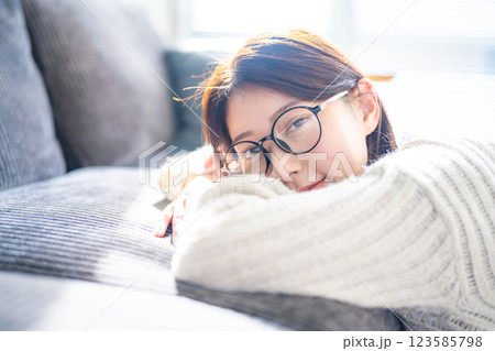 ソファでくつろぐ眼鏡の女性 ソファでくつろぐ眼鏡の女性 123585798