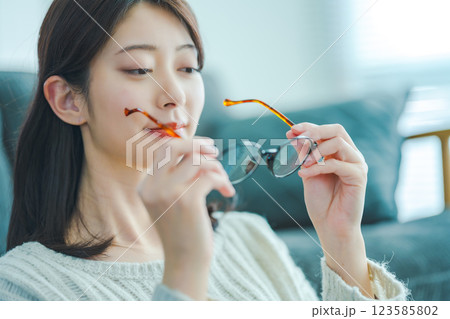 眼鏡を手に持ち考える女性 眼鏡を手に持ち考える女性 123585802
