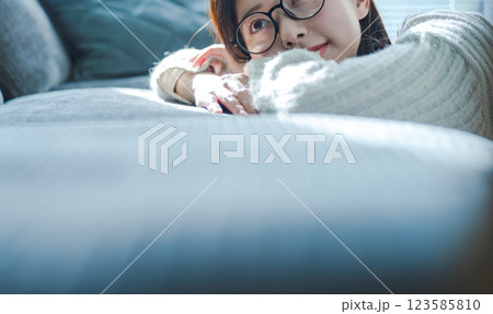 ソファでくつろぐ眼鏡の女性 123585810