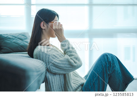 壁にもたれるメガネの女性 壁にもたれるメガネの女性 123585813