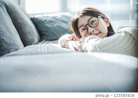 ソファでくつろぐ眼鏡の女性 ソファでくつろぐ眼鏡の女性 123585816