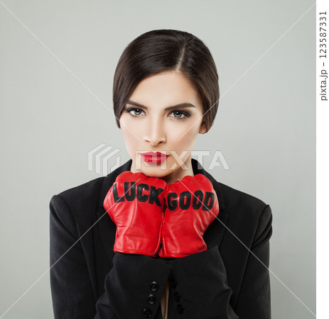 Successful fashionable woman with make-up and dark hair wearing red leather gloves Successful fashionable woman with make-up and dark hair wearing red leather gloves 123587331