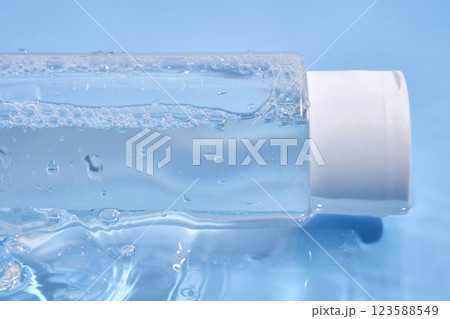 Bottle with cosmetic gel for face and body on blue background in water. 123588549