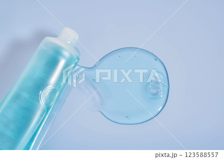 Shampoo pouring out of a small tube on a blue background. Texture. Shampoo pouring out of a small tube on a blue background. Texture. 123588557