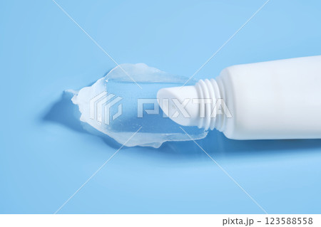 White lip balm in a tube on a blue background. The texture. White lip balm in a tube on a blue background. The texture. 123588558