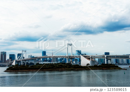 The Rainbow Bridge stretches across Tokyo Bay in Odaiba, creating a beautiful cityscape under cloudy skies. The Rainbow Bridge stretches across Tokyo Bay in Odaiba, creating a beautiful cityscape under cloudy skies. 123589015