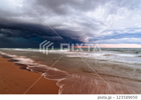A dramatic storm front looms over the tranquil ocean, contrasting nature's calm and powerful forces. 123589050