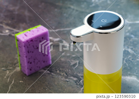 White dishwashing liquid dispenser on dark marble countertop White dishwashing liquid dispenser on dark marble countertop 123590310