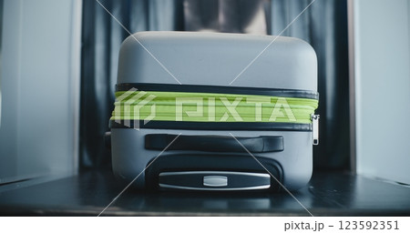 Airport Terminal: Suitcase Moving on Conveyor Belt from X-ray Scanning Metal Detector Airport Terminal: Suitcase Moving on Conveyor Belt from X-ray Scanning Metal Detector 123592351