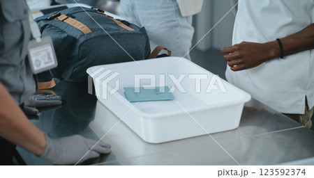 Airport Terminal: Close Up of Diverse People, Passengers Putting Personal Items, Bags in Trays Airport Terminal: Close Up of Diverse People, Passengers Putting Personal Items, Bags in Trays 123592374