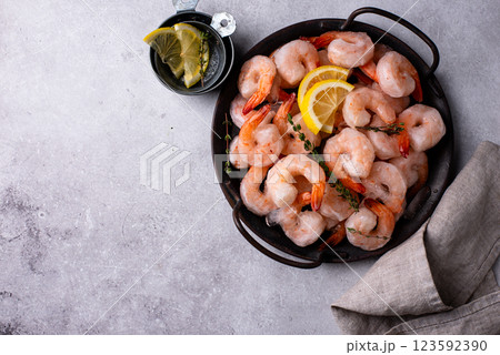 Frozen uncooked prawns or shrimps with lemon Frozen uncooked prawns or shrimps with lemon 123592390