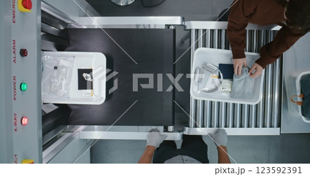 Top View on Diverse People, Passengers Putting Personal Items in Plastic Trays for Screening Procedures Top View on Diverse People, Passengers Putting Personal Items in Plastic Trays for Screening Procedures 123592391