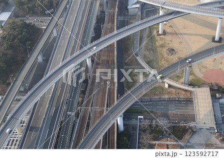 高層階のビルの部屋から見たジャンクションのループ橋を走る車と線路の風景 高層階のビルの部屋から見たジャンクションのループ橋を走る車と線路の風景 123592717