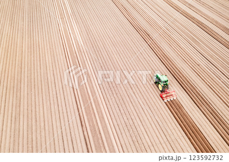 Aerial view of a tractor working on a plowed farmland 123592732