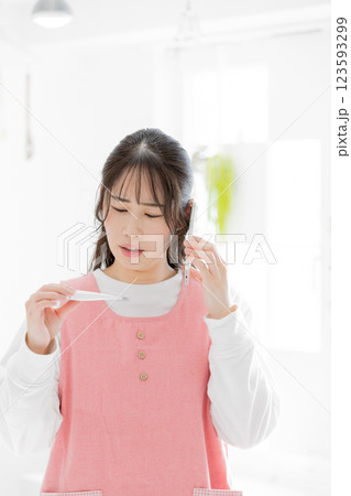 子供の発熱で連絡を入れる女性 123593299