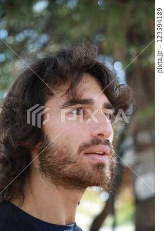 Long Hair Man Astonished To Read An Incomprehensible Poster On The Street Long Hair Man Astonished To Read An Incomprehensible Poster On The Street 123594189