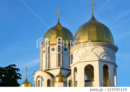 Shiny Christian church with golden domes, blue clear sky 123595129