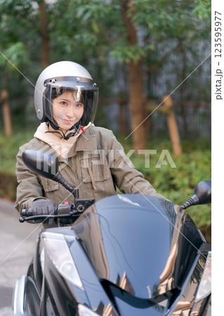 バイクに乗る若い女性 123595977