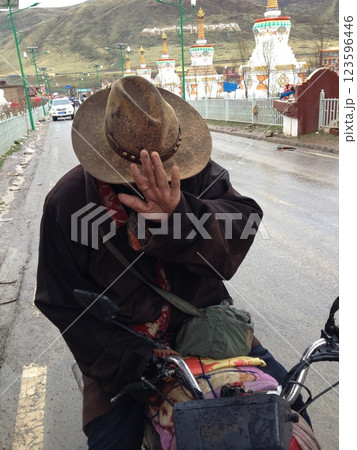 バイクに跨りじゃんけんをするチベット人 123596446