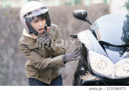 バイクの車体を見て驚く女性 バイクの車体を見て驚く女性 123596875