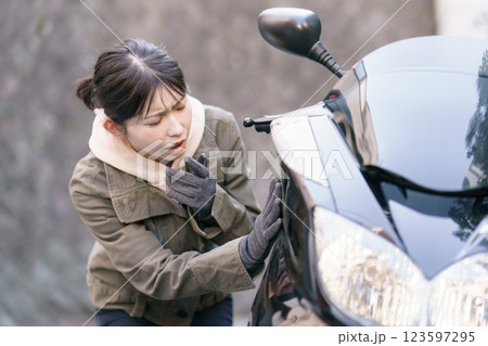 バイクの車体をチェックする女性 123597295